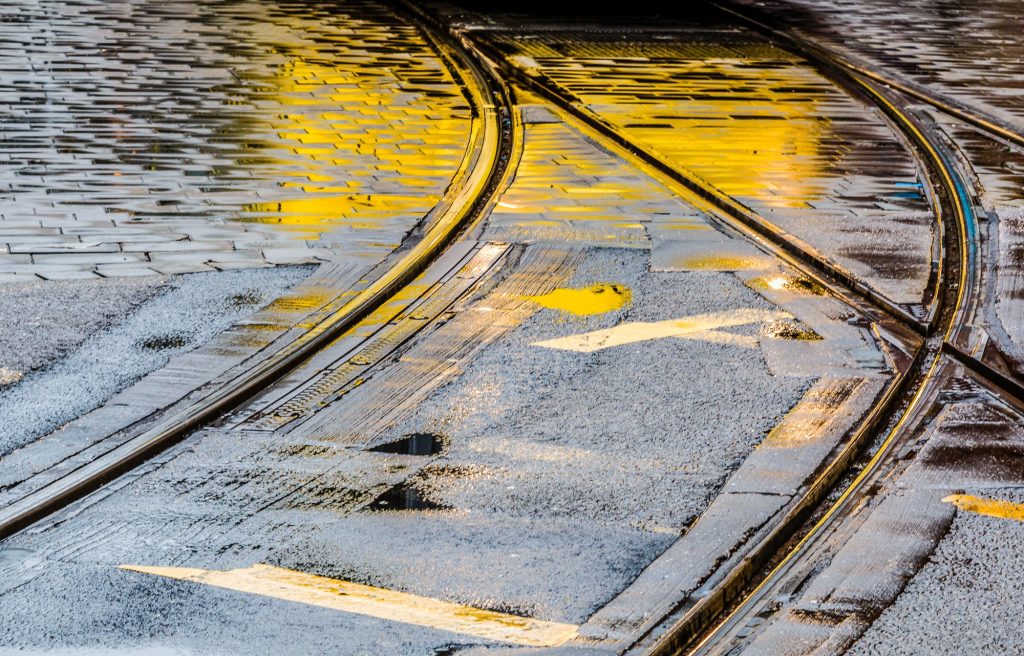 Rain-darkened tram tracks curve through Manchester – view 2