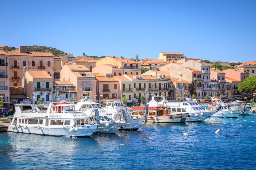 The harbour at La Maddalena is filled with small boats, clear blue water, Peak District – view 2