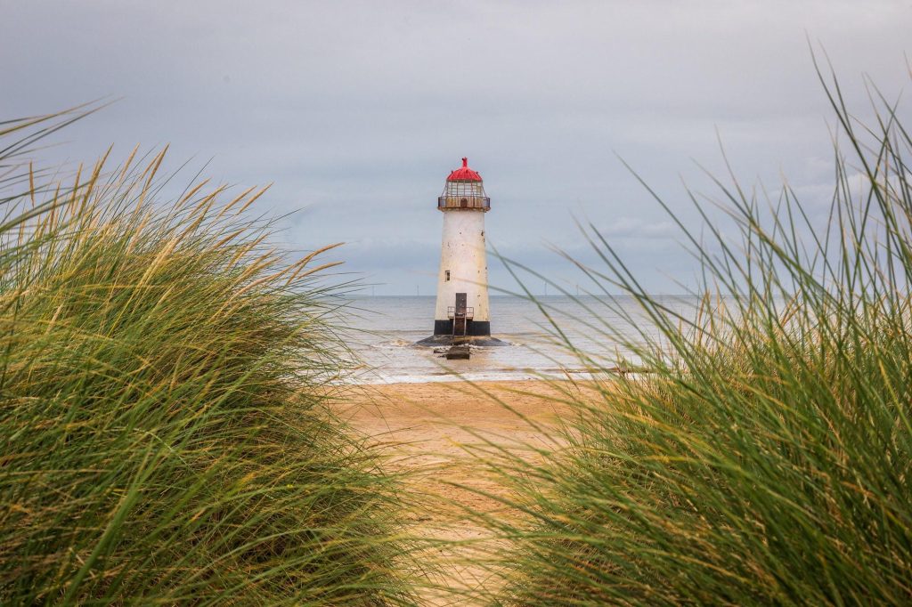 Seen through marram grass on the dunes, Talacre Lighthouse stands quietly against the open shoreline of the Dee Estuary – view 2