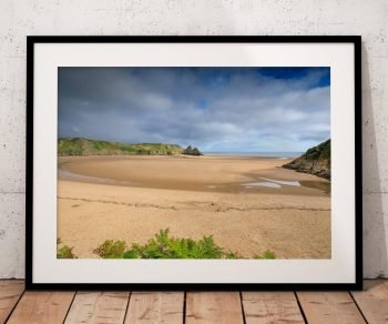 Three Cliffs Bay opens out across a wide sweep of pale sand in this tranquil view of the Gower Peninsula