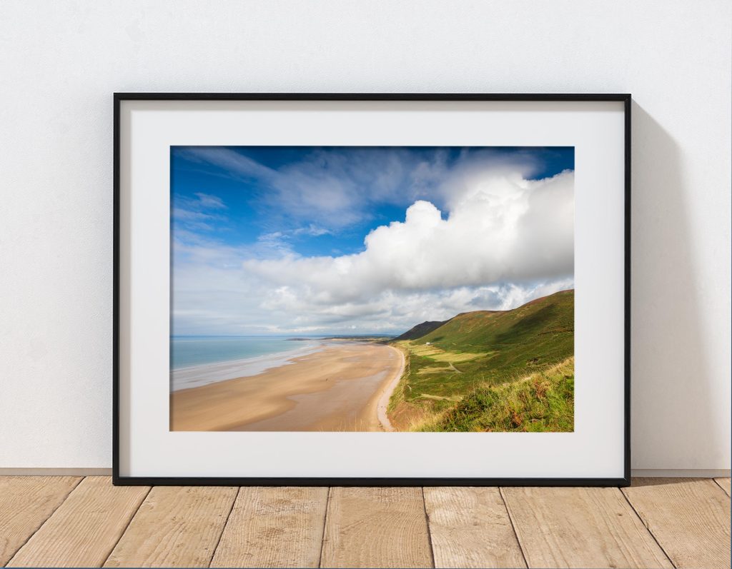Rhossili Beach is captured beneath dramatic clouds in late summer light on the Gower Peninsula