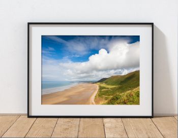 Rhossili Beach is captured beneath dramatic clouds in late summer light on the Gower Peninsula