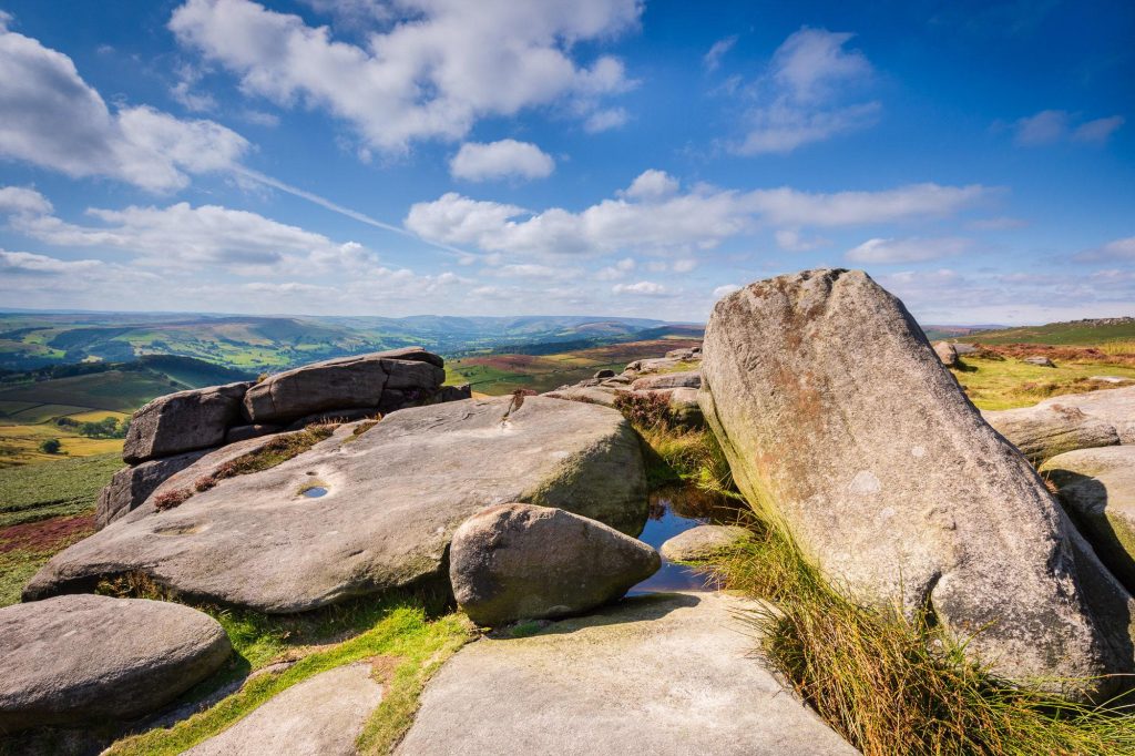 Weathered gritstone forms the foreground at Owler Tor, Peak District – view 2