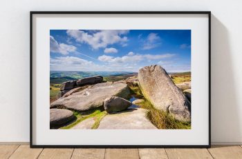 Weathered gritstone forms the foreground at Owler Tor, Peak District