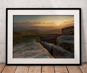 The rocky landscape of Higger Tor catches the last warm light of the day in this atmospheric Peak District view