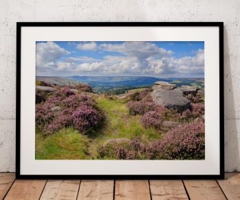 Heather moorland and weathered rocks lead into a broad view across the Hope Valley from Surprise View, Peak District