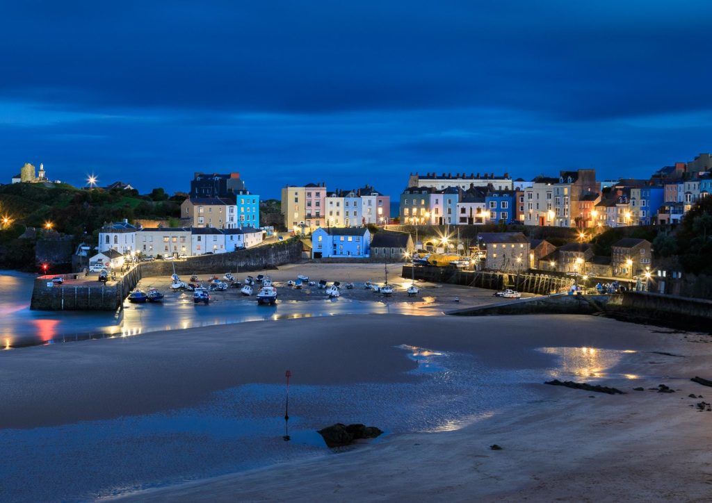 Tenby Harbour takes on a deep blue character after sunset, with the lights of the town, Wales – view 2