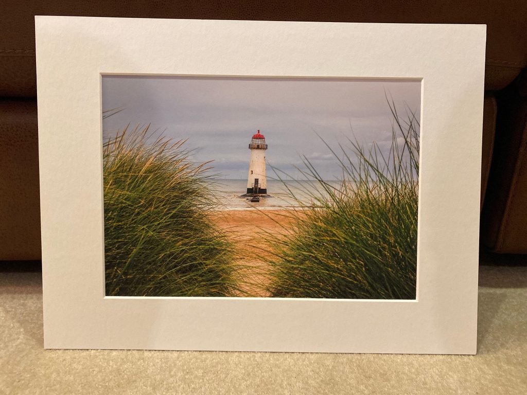 Seen through marram grass on the dunes, Talacre Lighthouse stands quietly against the open shoreline of the Dee Estuary – view 8