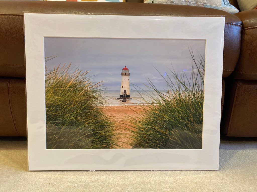 Seen through marram grass on the dunes, Talacre Lighthouse stands quietly against the open shoreline of the Dee Estuary – view 9