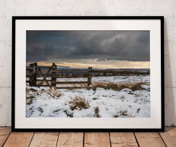 Snow-covered moorland stretches towards the hills near the Cat, Peak District