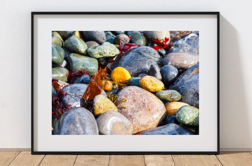 Rounded beach pebbles, polished by the sea, fill this close-up coastal photograph with colour and texture, Wales – view 3