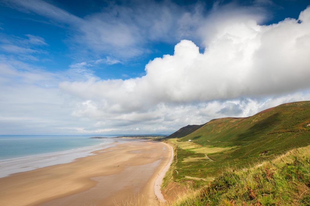Rhossili Beach is captured beneath dramatic clouds in late summer light on the Gower Peninsula – view 2