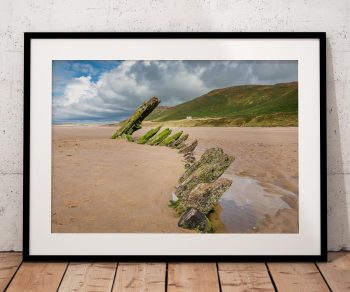 The weathered timbers of the Helvetia rise from the sands of Rhossili Beach, Wales