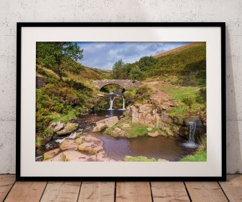 The packhorse bridge at Three Shires Head spans a small pool between waterfalls in the Peak District
