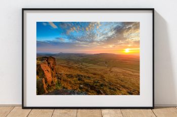 The setting sun spreads warm light across the high ground around Shining Tor, Peak District