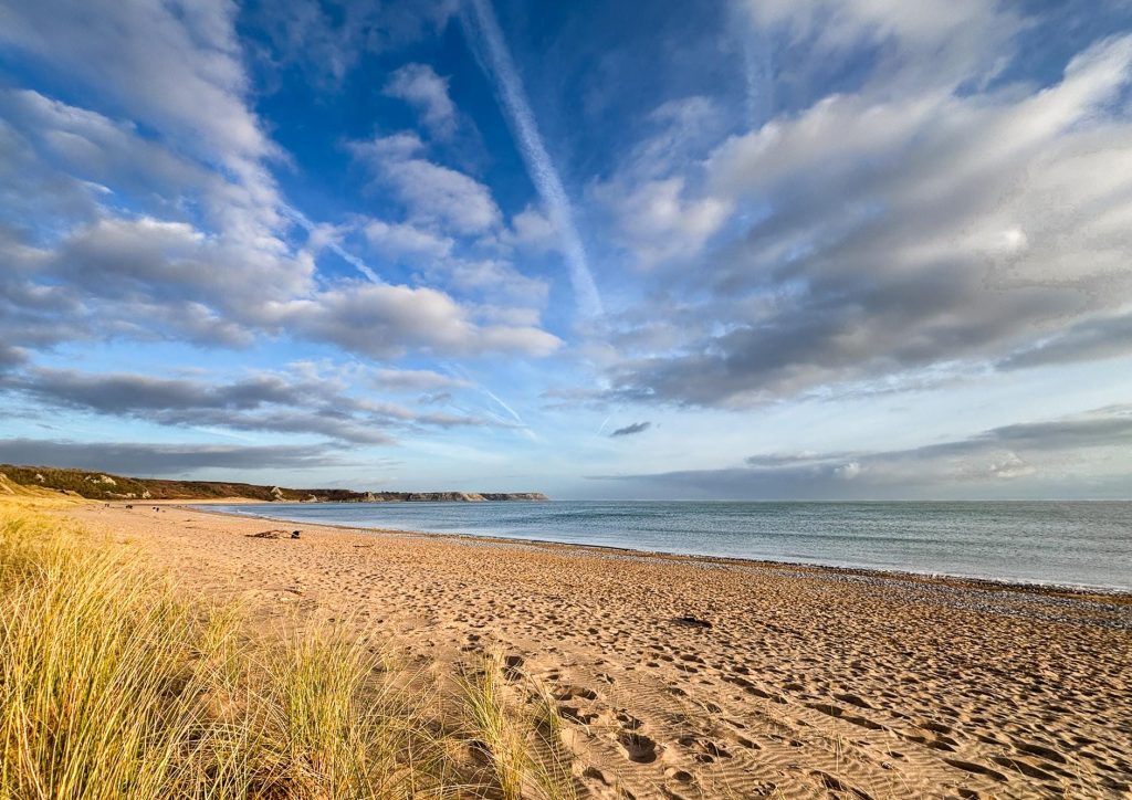 Late afternoon sunlight falls across the sandy sweep of Oxwich Bay on the Gower Peninsula – view 2