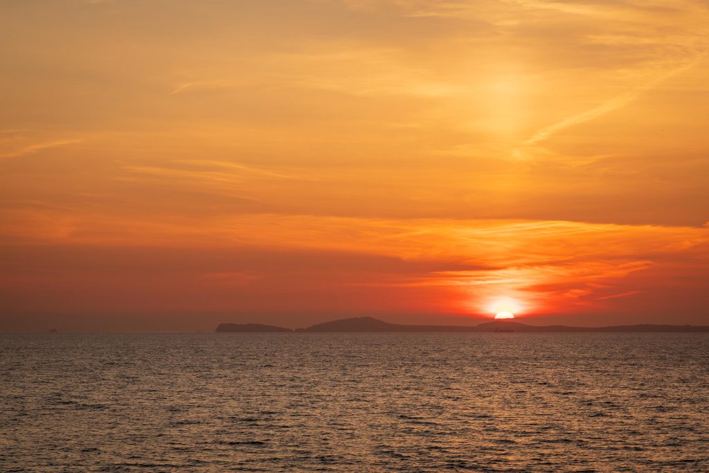 From Little Haven, the sun sinks towards the horizon beyond the St Davids Peninsula, filling the sky, Wales – view 2