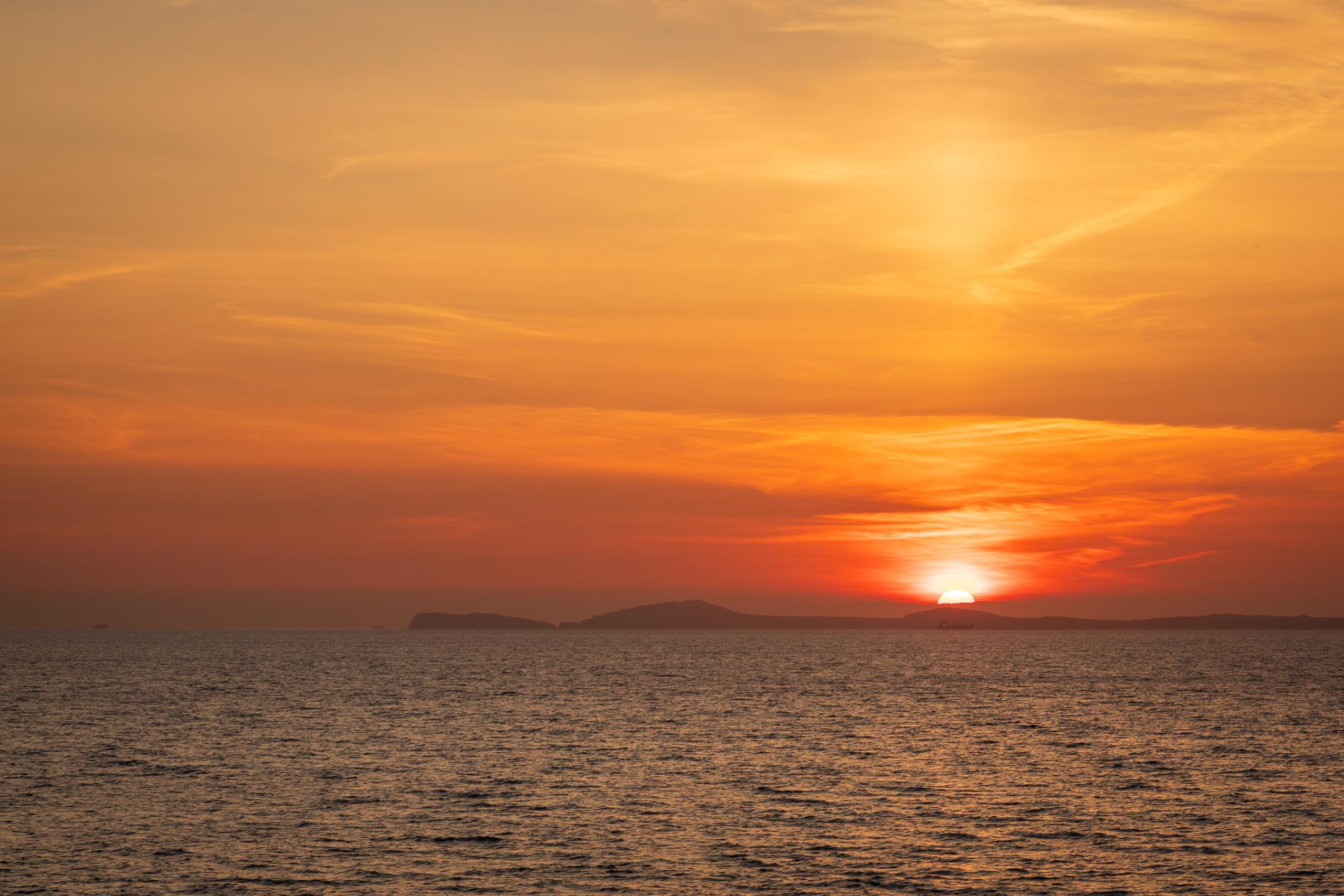 From Little Haven, the sun sinks towards the horizon beyond the St Davids Peninsula, filling the sky, Wales – view 2