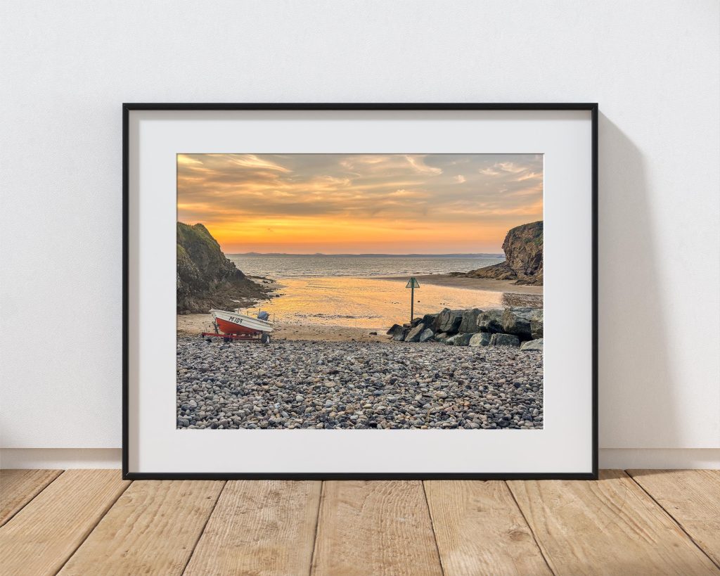 Little Haven Beach is caught in warm evening light as the tide recedes, Wales