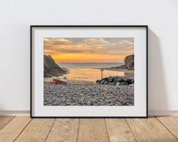 Little Haven Beach is caught in warm evening light as the tide recedes, Wales